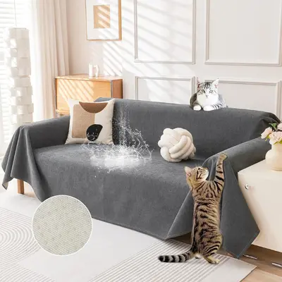 Dark grey Deep Dream couch cover draped across a sofa with cats pictured nearby.