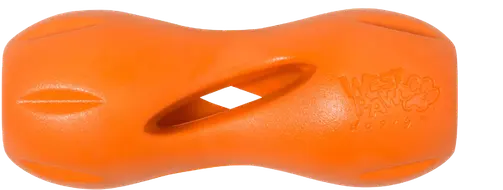 Orange West Paw Qwizl holding a long dog treat